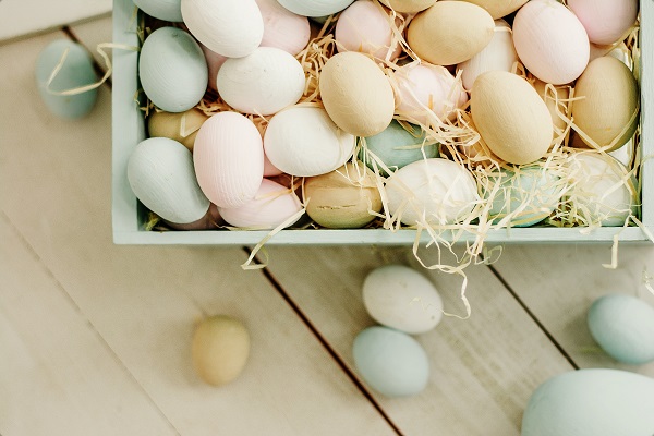 A box of pastel easter eggs on a wood table