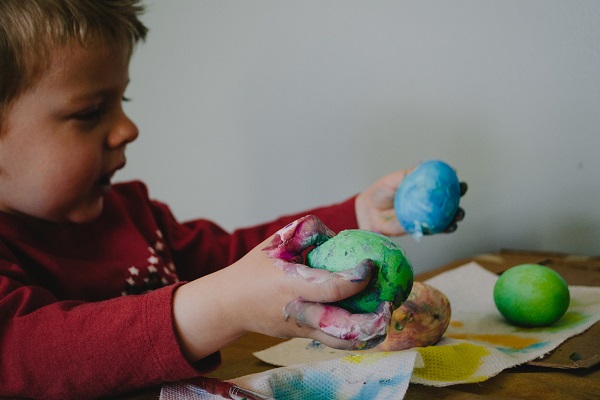 A small child playing with paint and playdough
