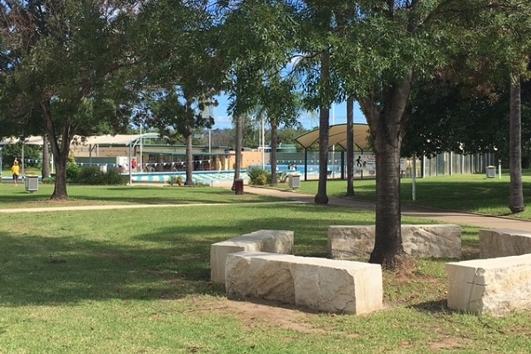 open grassed area with swimming pool in the distance