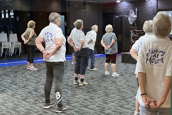 A group of over 50's practice a stretching exercise